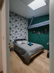 a bedroom with a bed and a green wall at Maison de ville le 101 - 3 chambres - garage in Angoulême