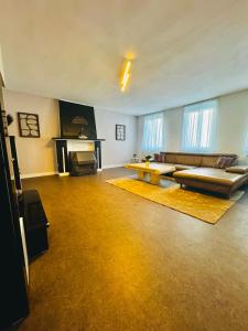 a large living room with a couch and a fireplace at Appartement De panne in De Panne