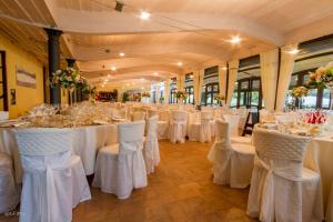uma sala com mesas e cadeiras com toalhas de mesa brancas em San Pietro Sopra Le Acque Resort & Spa em Massa Martana