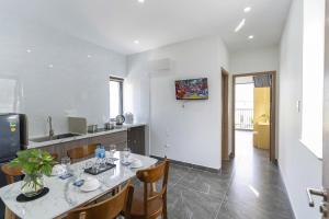 a kitchen with a table and some chairs in a room at Tidal Mist Homestay in Long Hai