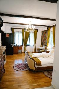 a bedroom with a large bed and a chandelier at Casa Poveste Pensiunea-Muzeu in Câmpulung Moldovenesc