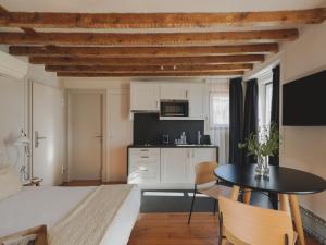 a room with a bed and a table and a kitchen at Casa Solayme Vitória in Lisbon