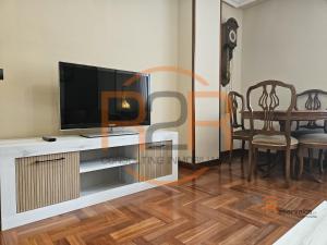 a living room with a television and a dining room table at R2R - El Raitán - 1A122 in Gijón