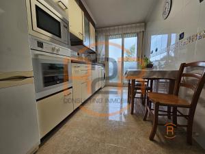a kitchen with a table and a dining room at R2R - El Raitán - 1A122 in Gijón