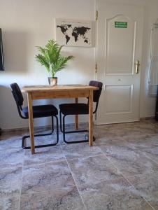 a wooden table with two chairs and a plant on it at Finca el Gaudi, casita Catharina in L'Ampolla
