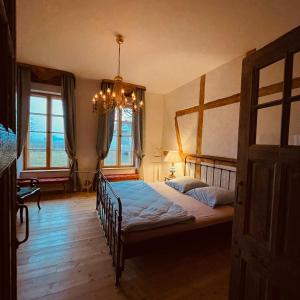 a bedroom with two beds and a chandelier at Die Orchidee - Gutshaus Bückling in Rambin