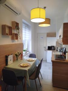 a kitchen with a table and chairs and a kitchen with a dining room at Lady Mabel's apartment near to Aréna, Puskás Stadion and City Park, with Guarded Parking place in Budapest +32 photos