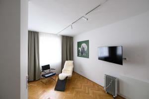 a living room with a tv and a chair at Gut Purbach in Purbach am Neusiedlersee
