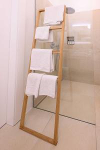 a towel rack with white towels on it in a bathroom at Gut Purbach in Purbach am Neusiedlersee +39 photos