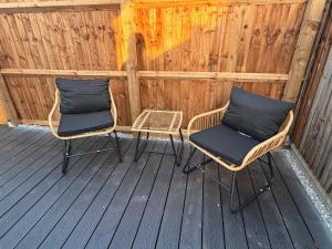 two wicker chairs sitting on a wooden deck at The old greengrocers Battlesbridge in Rawreth