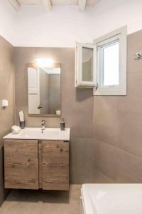 a bathroom with a sink and a mirror and a tub at Axas House in Stení +17 photos