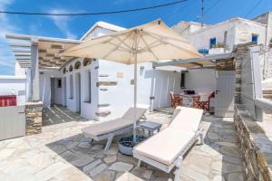 a patio with a bench and an umbrella at Axas House in Stení