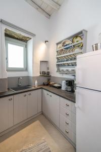 a kitchen with white cabinets and a white refrigerator at Axas House in Stení