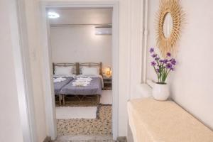 a bedroom with a bed and a vase with purple flowers at Aioliana Apartments in Mytilene