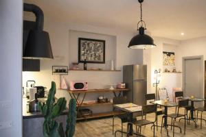 a kitchen with a table and chairs and a refrigerator at INDUSTRIAL CHIC HOUSE - Private parking in Orvieto