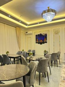 a dining room with tables and chairs and a chandelier at ANNUR Boutique Hotel in Samarkand