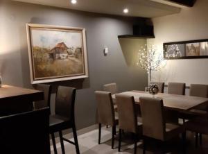 a dining room with a table and chairs and a painting at Belajec Wine & Nature Retreat in Veliko Brdo