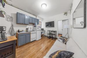 a living room with a couch and a kitchen at Chic Times Square 1-Bedroom Apartment - Hosts 4 in New York