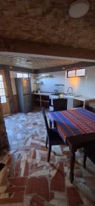 a living room with a table and a kitchen at Domo del desierto in San Pedro de Atacama