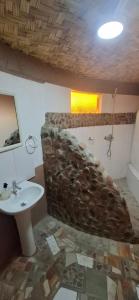 a bathroom with a sink and a stone wall at Domo del desierto in San Pedro de Atacama +36 photos