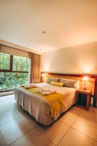 a bedroom with a large bed and a window at Hotel Tré Iguazú in Puerto Iguazú +5 photos