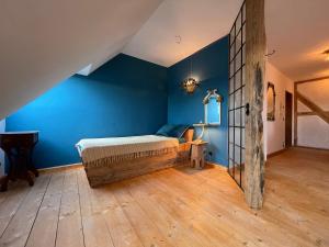 a bedroom with a bed in a blue wall at Die Perle - Gutshaus Bückling in Rambin