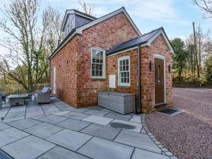 a red brick building with a patio with a bench at Broadmoor Chapel in Hereford