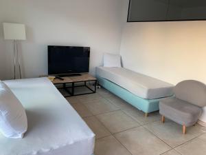 a room with a bed and a chair and a tv at Cloche d'or in Luxembourg