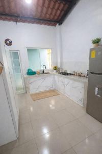 a white kitchen with a sink and a refrigerator at Mini Bamboo Nest con Desayuno in Puyo