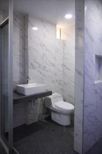a white bathroom with a toilet and a sink at Peruyork Arbnb - Calle España in Chiclayo