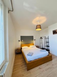 a bedroom with a bed and a large window at Le Clemenceau - Appartements meublés in Gien