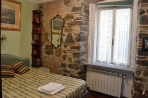 a bedroom with a bed and a brick wall at Affittacamere Rilke in Trieste