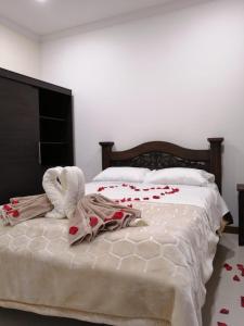 a bedroom with a bed with roses on it at HOTEL El MONARCA in Tunja