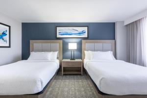 a hotel room with two beds and a table with a lamp at The Simon Hotel Sydney in Sydney