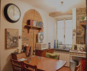 a kitchen with a table and a clock on the wall at Affittacamere Rilke in Trieste