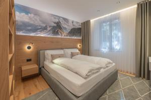 a bedroom with a bed with a painting on the wall at Appartament Seceda in San Sigismondo