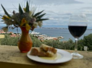 a plate of food and a glass of wine on a table at Family Apartment Sofija in Preko