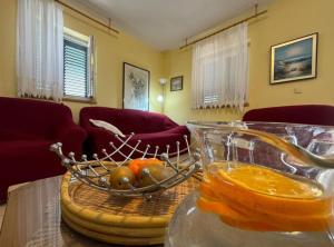 a bowl of fruit on a table with a bowl of oranges at Family Apartment Sofija in Preko +14 photos