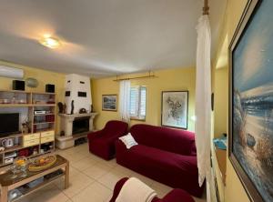 a living room with a red couch and a tv at Family Apartment Sofija in Preko
