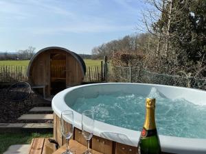 a bottle of champagne and two wine glasses in a tub at Au bois colin in Durbuy