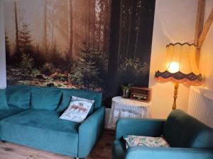 a living room with a blue couch and a lamp at Leśna Ostoja in Goworów +64 photos