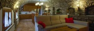 a living room with a couch and a stone wall at Casa Rural O Fraginal in Guasillo