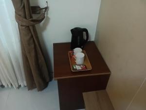 a small table with two cups and a tea pot on it at Ghomes in Lagos