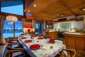 a dining room with a table with red dishes on it at Chalet Les Solans in Les Allues