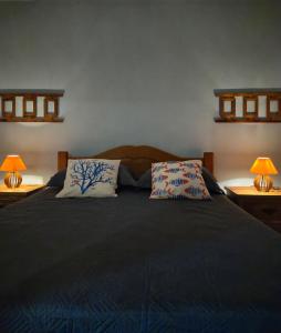 a bedroom with a large bed with two lamps at Luz Residence beach house in Cabo Frio +55 photos