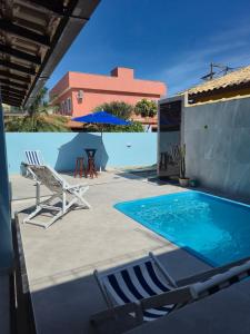 a patio with chairs and a swimming pool at Luz Residence beach house in Cabo Frio