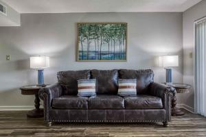 a brown leather couch in a living room with two lamps at 1023 English Mtn Condo by Beyond Expectations in Sevierville