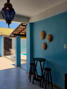 a room with two stools and a blue wall at Luz Residence beach house in Cabo Frio