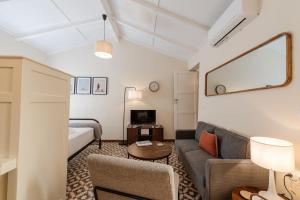 a living room with a couch and a tv at Kamari Guest House Corfu in Corfu International Airport I Kapodistrias
