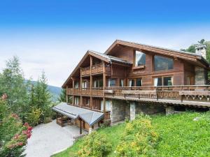 a large wooden house with a balcony at Chalet Les Solans in Les Allues